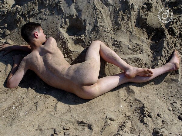 Fima enjoys rolling in the sand while completely naked