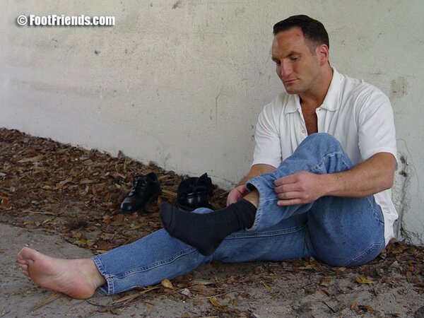 Duke reveals his thick soles and toes after removing his black socks