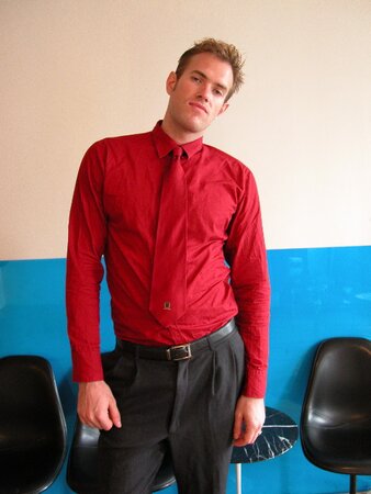 Kurt shows off his size 13 feet while posing in a stylish red shirt