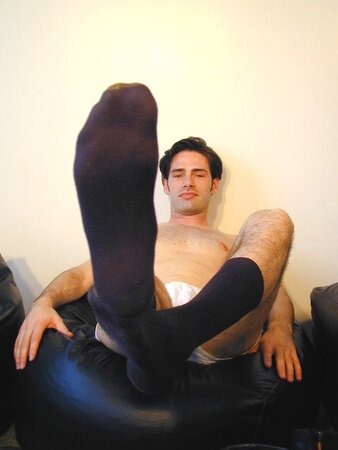 Brunette Christopher flaunts his feet in dark socks for the camera